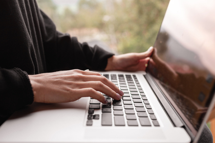 Email marketing and newsletter concept. Hand of man sending message and laptop